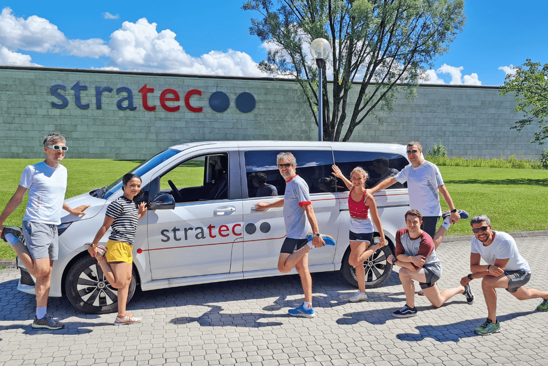 STRATEC employees in their running clothes posing in front of the STRATEC company car in Austria