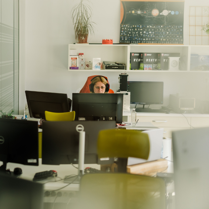 STRATEC colleague in an office in front of a desk sitting in a meeting call in Romania
