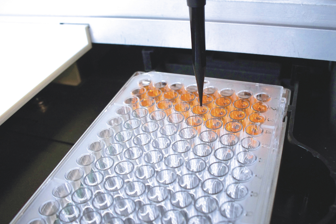 Laboratory machine with one pipette filling up the testing tubes in a tube rack for ELISA testing at Diatron Laboratory machine with one pipette filling up the testing tubes in a tube rack for ELISA testing at Diatron