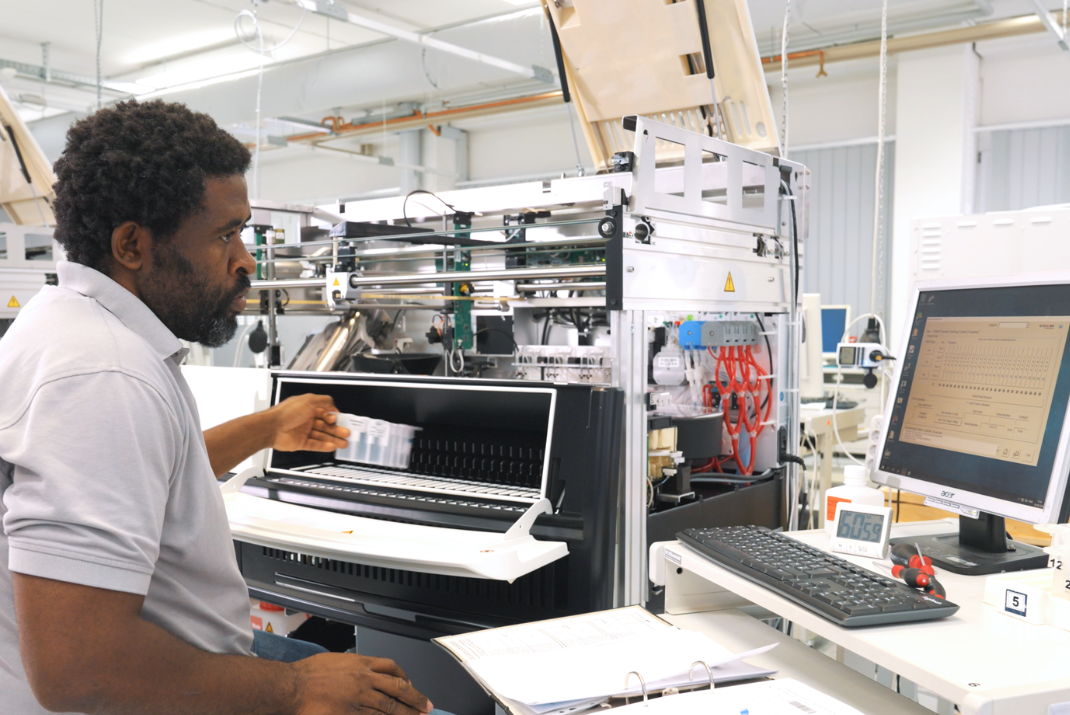 STRATEC employee testing an analyzer system’s functionality in the production hall 