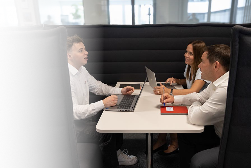 Colleagues sitting in a working booth talking about work