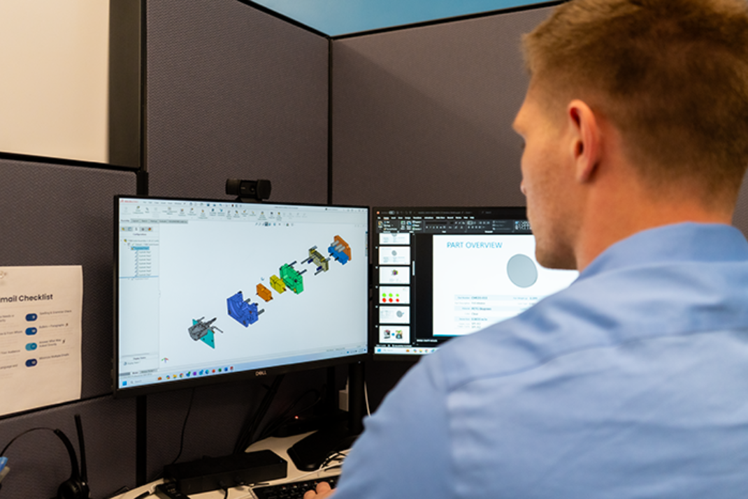 Natech employee looking at screens in front of him that is showing the individual assembly parts of a system