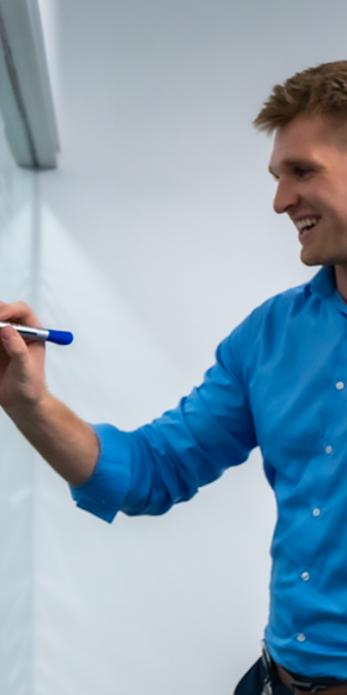 Employee with a blue pen in his hand, writing something on the flip chart Employee with a blue pen in his hand, writing something on the flip chart