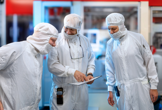 Three laboratorians with safety gear talking work Three laboratorians with safety gear talking work